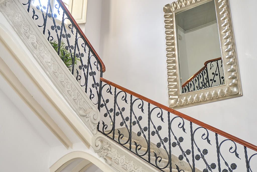 Luxurious stone-facade boutique hotel in Sóller, Mallorca, with elegant balconies and lush tropical gardens against a scenic mountain backdrop.