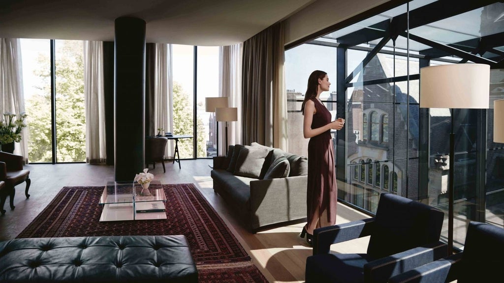 Luxurious penthouse suite with sleek modern design, floor-to-ceiling windows overlooking Amsterdam, elegant neutral tones, and contemporary minimalist furnishings