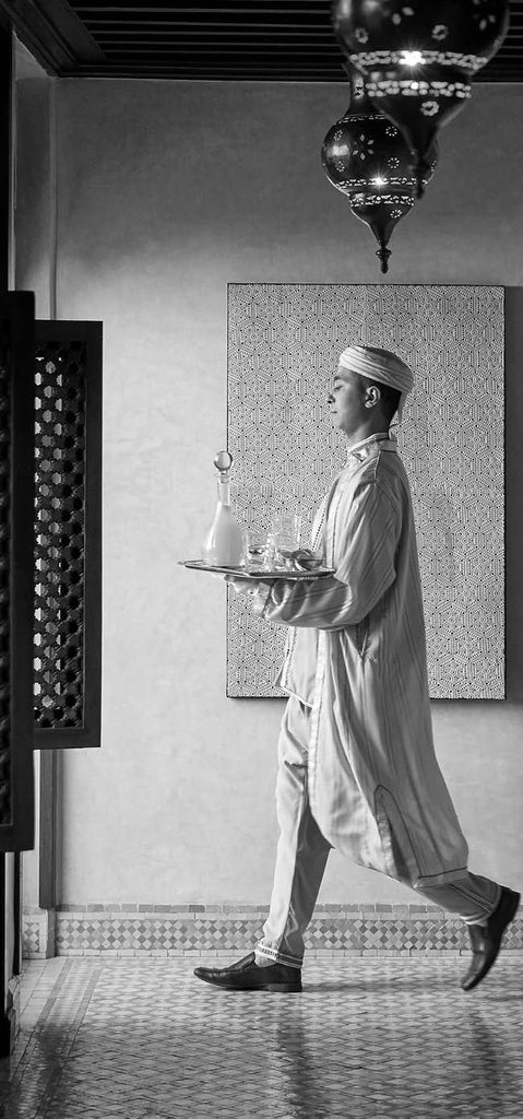 Luxurious Art Deco hotel exterior in Casablanca with grand white facade, ornate balconies, palm trees, and traditional Moroccan archways