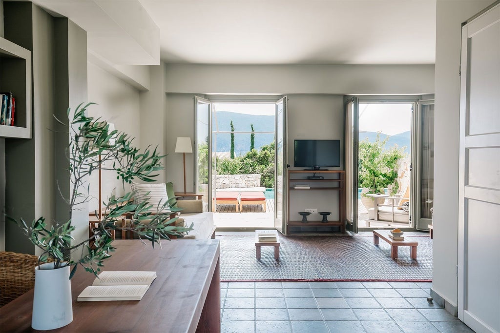 Elegant two-story maisonette at Emelisse Nature Resort, featuring white stone walls, wooden balcony, and panoramic Ionian Sea view in Kefalonia, Greece