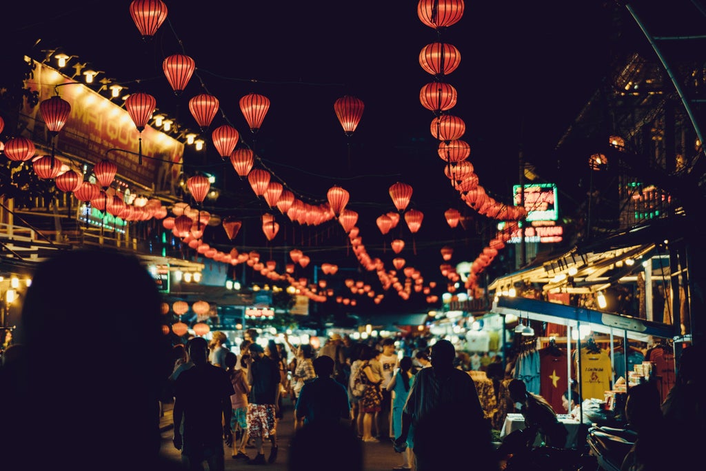 Elegant guide leading travelers through Hoi An's ancient streets, vibrant lanterns, and traditional yellow buildings during golden afternoon light