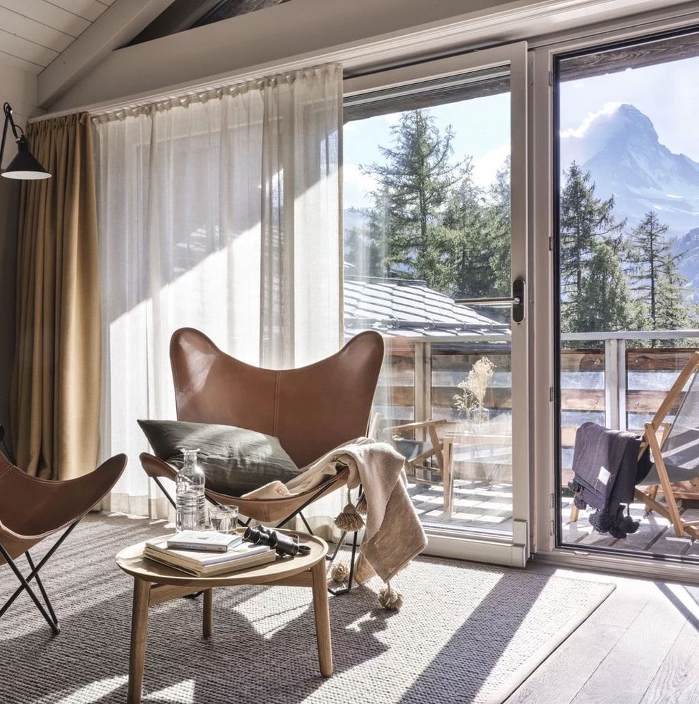 Luxury mountain resort with modern wooden architecture nestled in snowy Swiss Alps, featuring panoramic glass windows and balconies