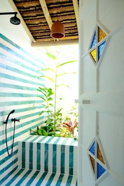 Rustic-chic Brazilian hotel room with terracotta ceramic tiles, minimalist wooden furnishings, and soft white linens in a serene tropical setting