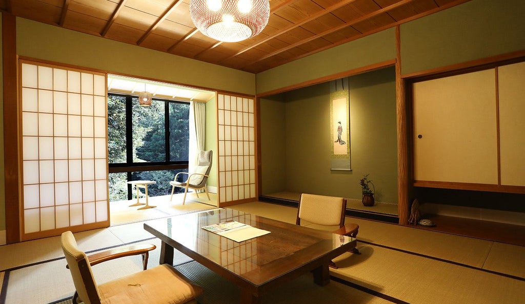 Elegant Japanese suite with minimalist wood design, traditional tatami flooring, sliding shoji screens, and modern rainfall shower reflecting zen luxury hospitality