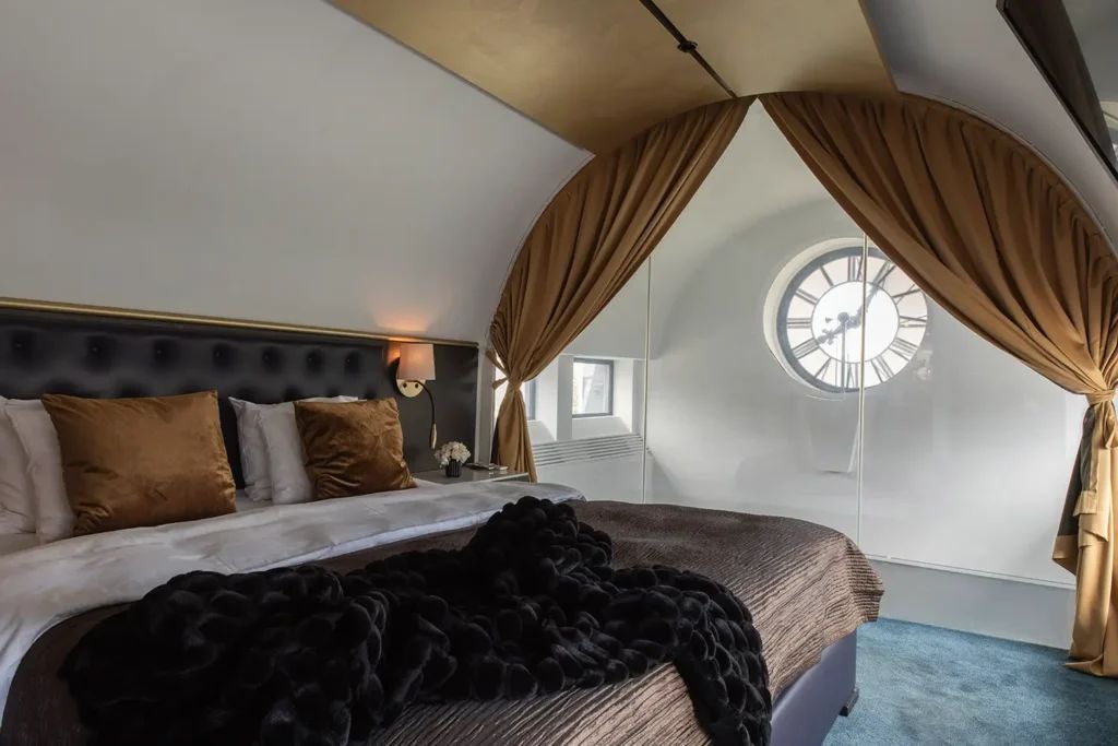 Elegant clock-themed luxury suite with modern Swedish design, featuring ornate timepiece, plush golden textiles, and sophisticated neutral color palette