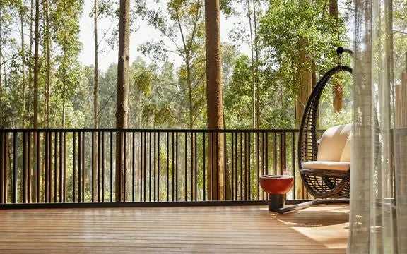 Luxurious wooden treehouse suite nestled in lush Rwandan rainforest, blending elegant design with natural surroundings at One&Only Gorilla's Nest resort