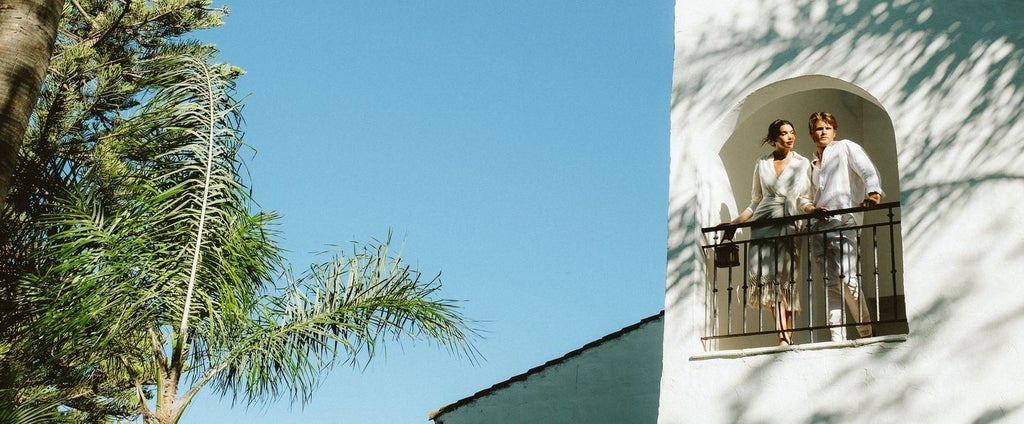 Luxurious white minimalist facade of Nobu Hotel with sleek architecture, palm trees, and modern Mediterranean design against blue sky backdrop