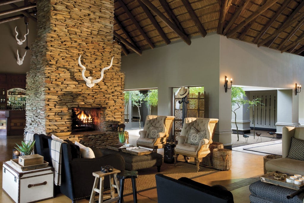 Luxurious safari lodge suite with private deck overlooking Sabie River, featuring plunge pool and outdoor seating in natural setting