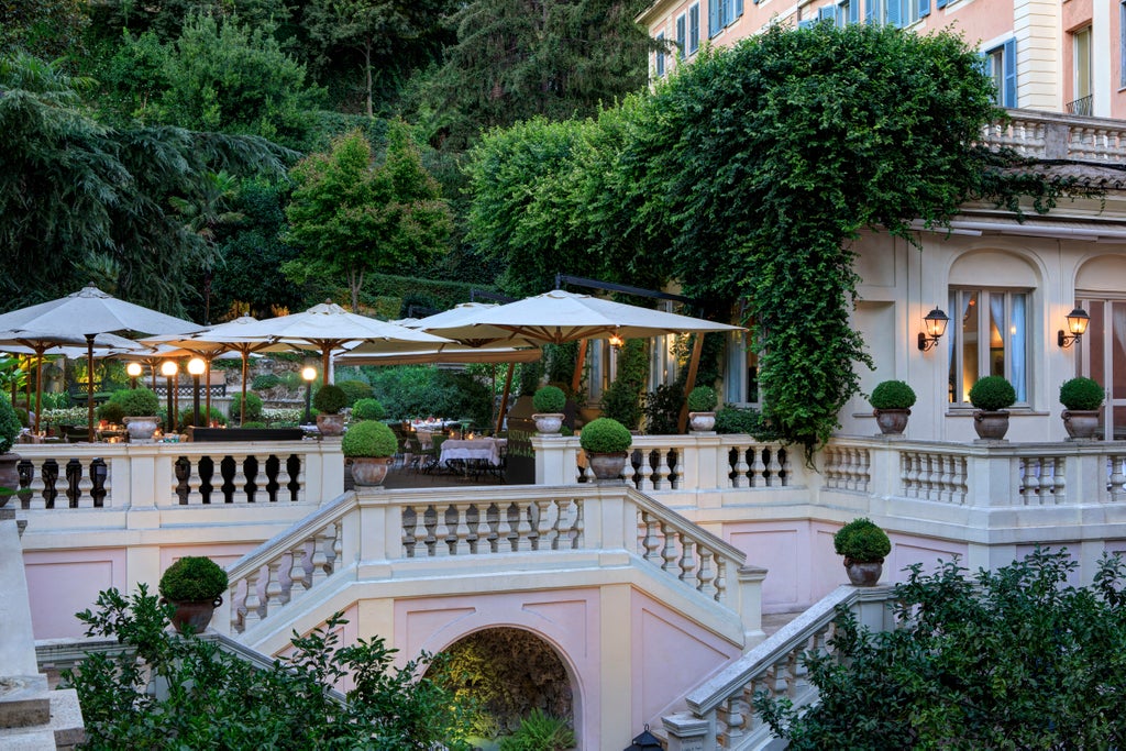 Elegant five-star Hotel de Russie facade in Rome with classic Italian architecture, ornate balconies, and lush greenery on terrace