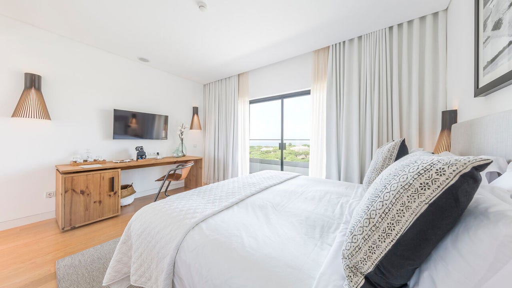 Contemporary beachfront hotel with floor-to-ceiling windows, sleek wooden decking, and infinity pool overlooking the Atlantic Ocean in Portugal