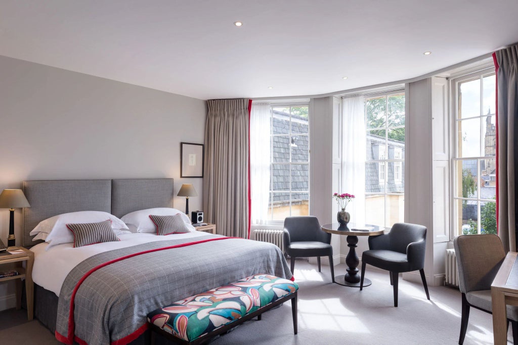 Elegant classic hotel room with vintage wooden furnishings, plush white bedding, and rich mahogany accents at historic Old Bank Hotel in United Kingdom.