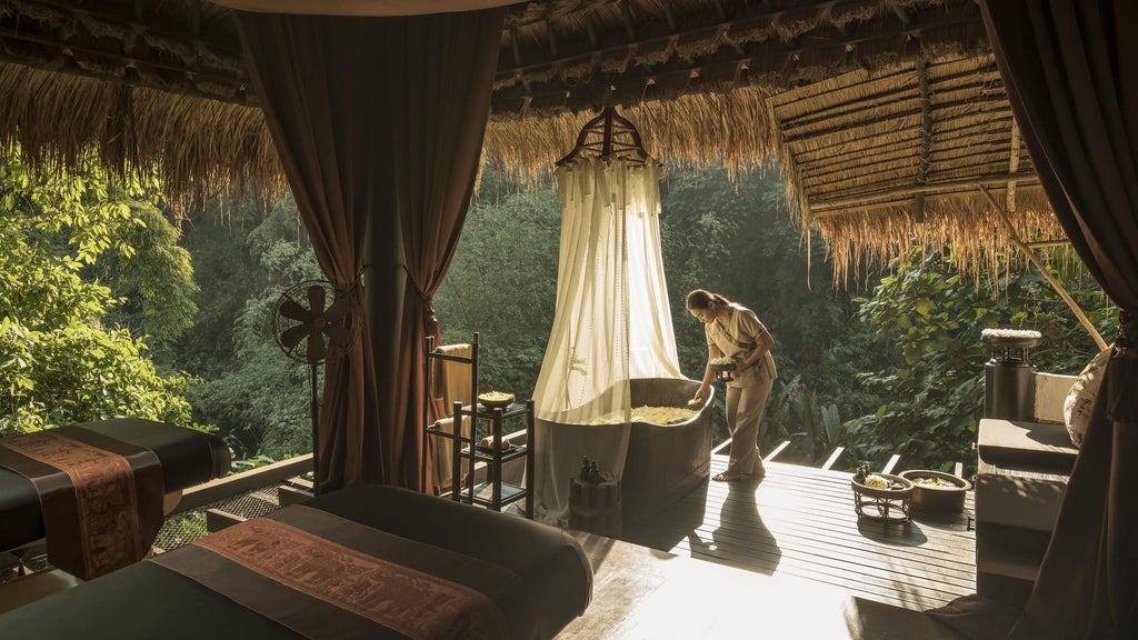 Luxurious safari-style tent villa perched on stilts amid tropical jungle canopy, featuring private deck with jungle views at sunset