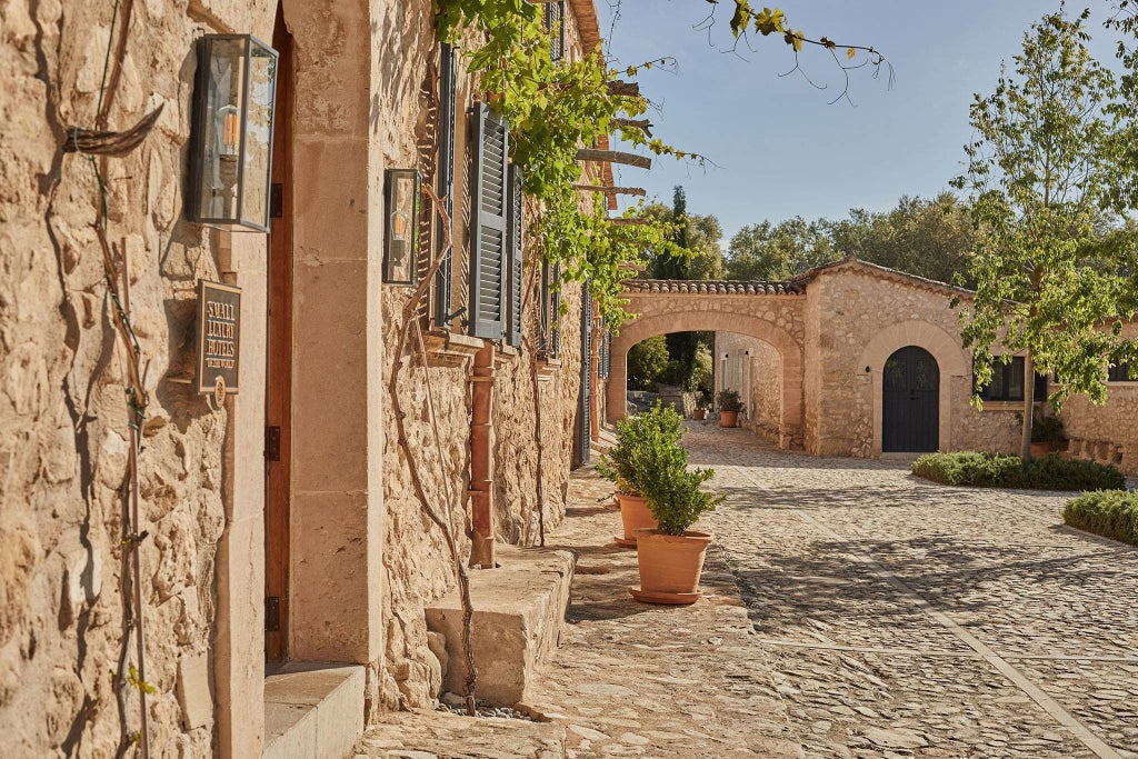 Mediterranean stone villa with infinity pool overlooking rolling hills, surrounded by olive groves and lavender gardens at sunset