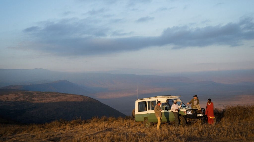 Luxurious safari tent overlooking dramatic Ngorongoro Crater landscape with golden sunlight and sweeping Tanzanian wilderness panorama at Nomad Entamanu camp