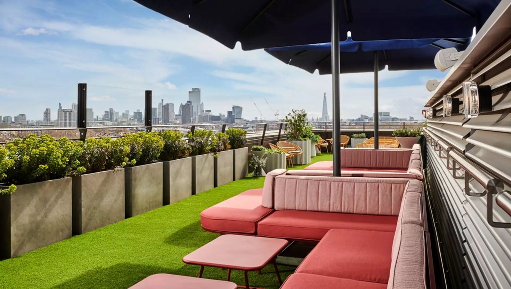 Luxurious hotel exterior at dusk, sleek modern architecture with glass facade, London cityscape visible, contemporary design with dramatic lighting