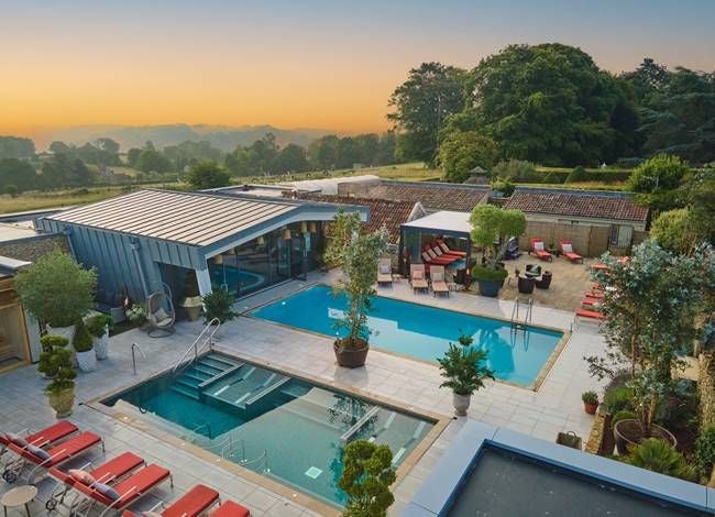 Luxurious spa hotel with modern architecture, featuring elegant interiors, expansive windows, and a serene landscape in the United Kingdom countryside