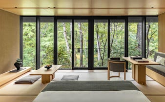 Traditional Japanese wooden pavilion nestled in serene forest, featuring minimalist architecture and tranquil garden at Aman Kyoto resort