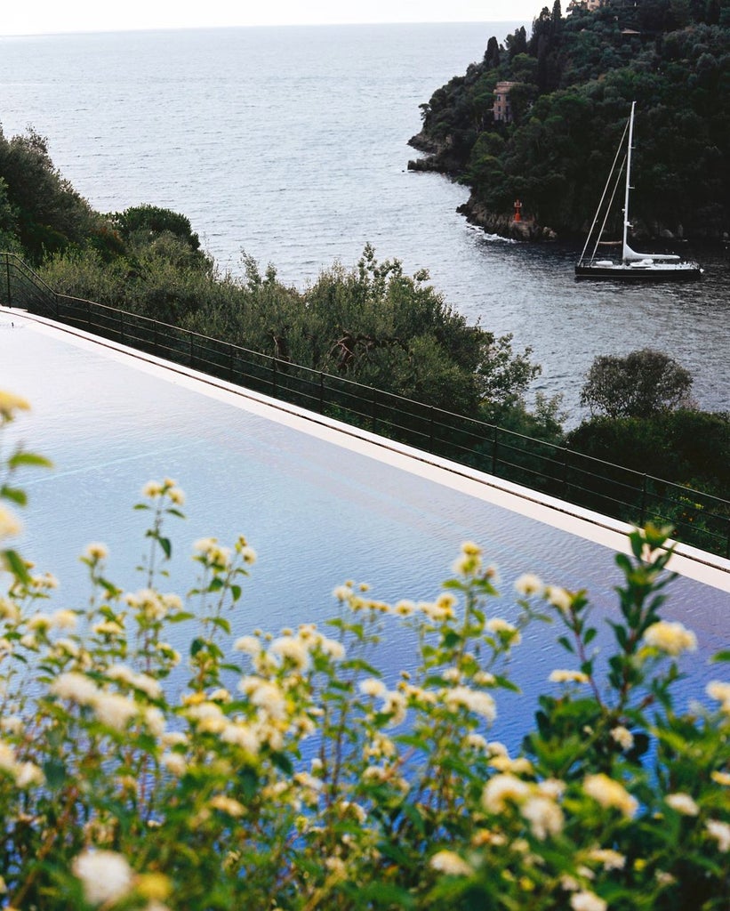 Five-star hillside hotel with cascading infinity pools overlooking the Amalfi Coast, surrounded by Mediterranean gardens and terraces