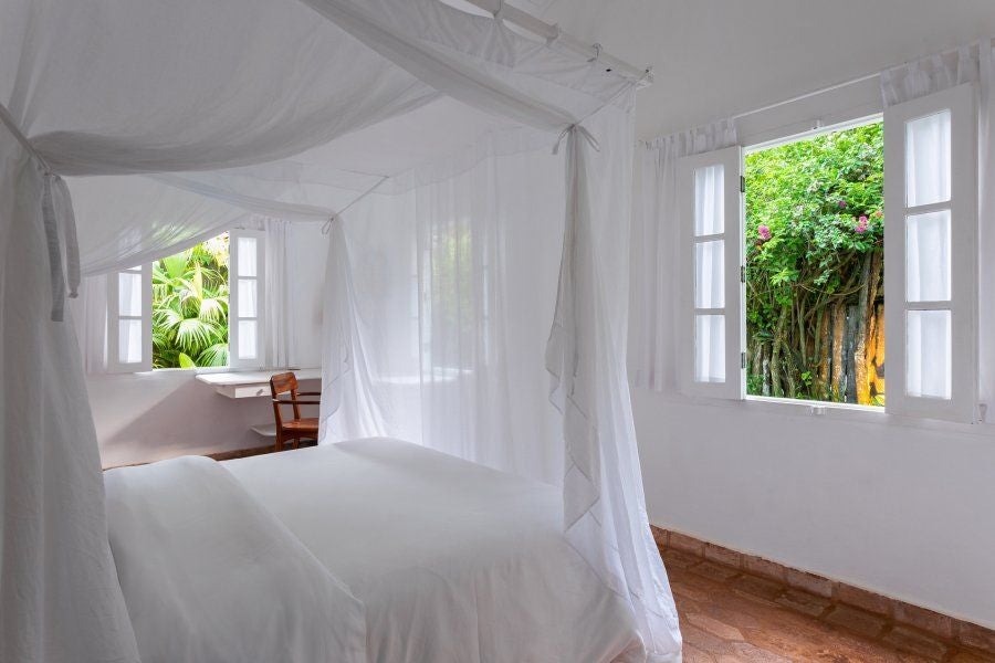 Rustic wooden interior of UXUA Casa Hotel luxury suite in Trancoso, Brazil, with warm earth tones and minimalist tropical design aesthetic