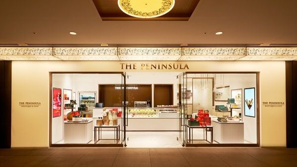 Grand entrance of The Peninsula Bangkok hotel with illuminated driveway fountain, tropical landscaping and elegant colonial architecture