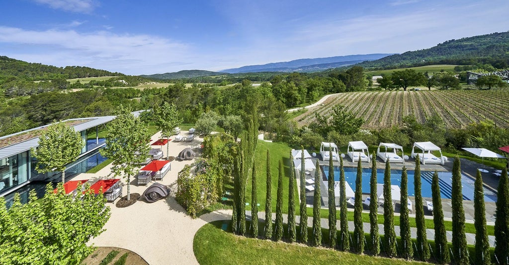 Modern luxury hotel nestled in Provence countryside, featuring minimalist architecture, floor-to-ceiling windows and serene infinity pool