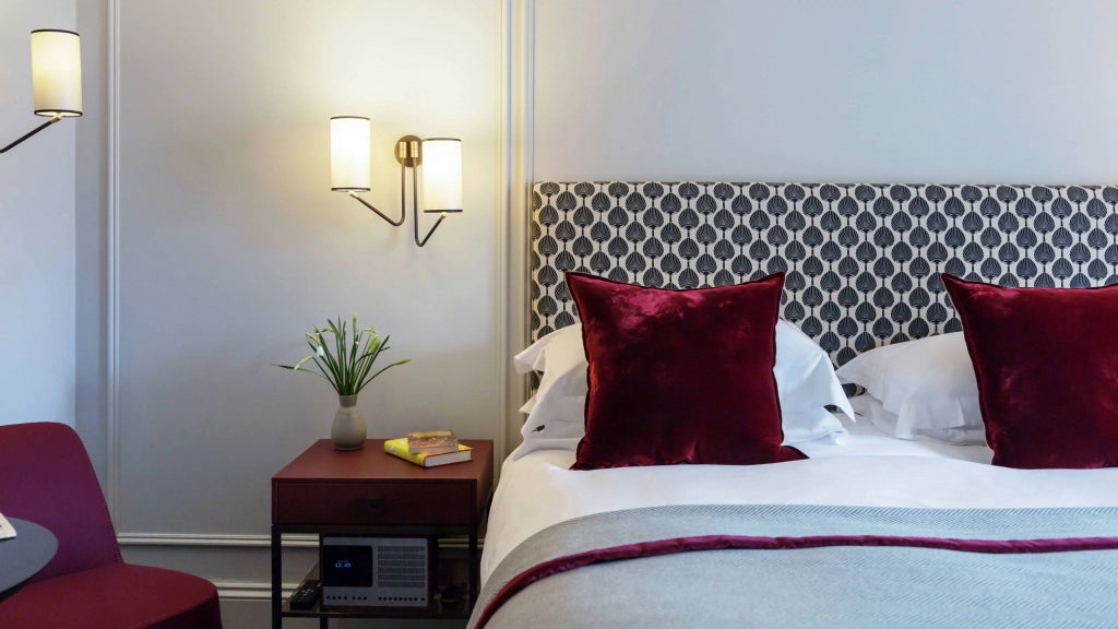 Elegant deluxe hotel room with crisp white linens, classic wooden furniture, and soft ambient lighting in a historic United Kingdom parsonage setting