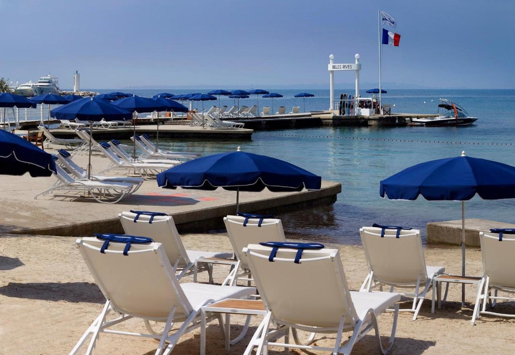 Elegant Art Deco hotel with white facade and blue shutters overlooking Mediterranean Sea in Antibes, French Riviera at sunset