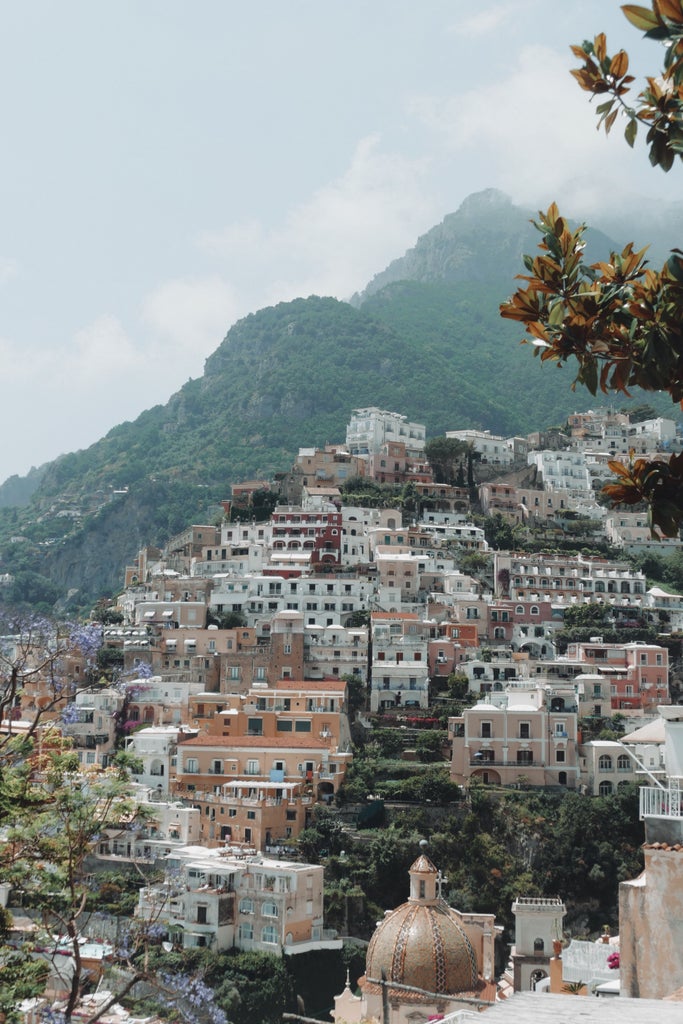 Scenic luxury hillside villas and cliffside buildings overlooking turquoise Mediterranean waters along Italy's dramatic Amalfi Coast