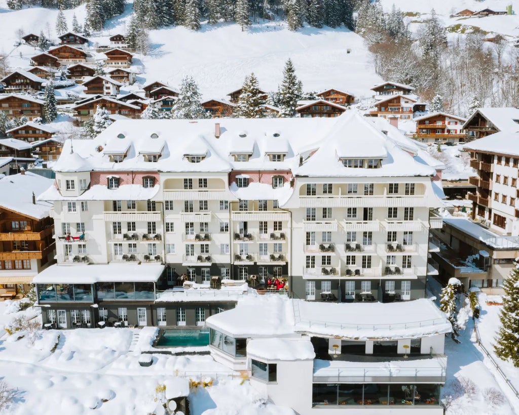 Luxury Alpine hotel with modern glass and wood design, nestled in scenic mountain landscape with snow-capped peaks and contemporary minimalist architecture