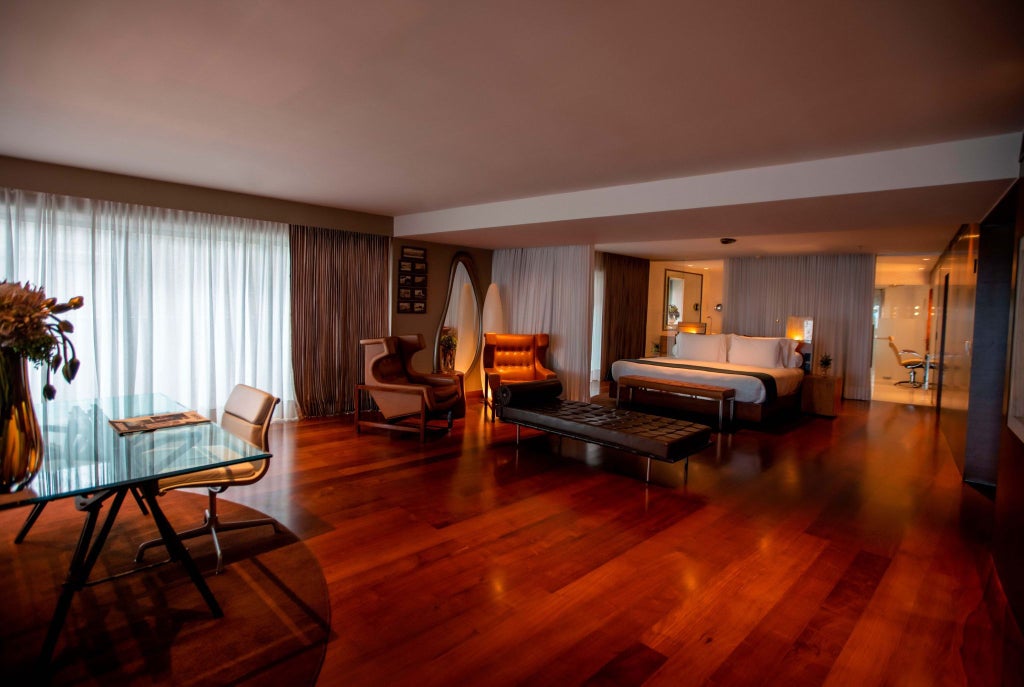 Elegant Brazilian suite with panoramic ocean view, floor-to-ceiling windows, modern minimalist design, and luxurious white furnishings at scenset hotel