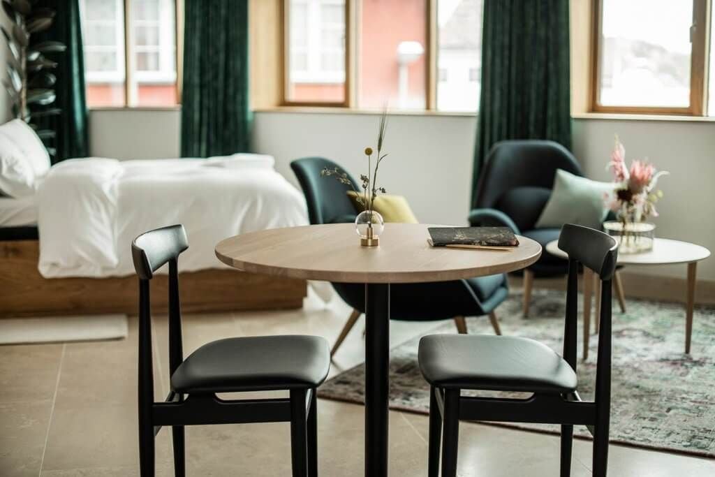 Luxurious superior suite at Scenset Hotel featuring modern Scandinavian design, plush bedding, panoramic coastal view, and elegant minimalist Nordic decor