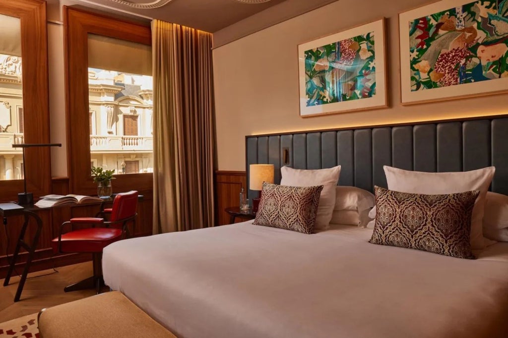 Luxurious grand suite with panoramic city views, elegant king bed, modern marble bathroom, and sophisticated Spanish hotel decor in warm neutral tones