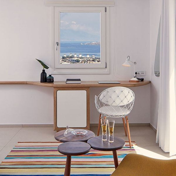 Luxurious white-washed ocean suite at Myconian Kyma hotel, featuring minimalist design, private balcony, and breathtaking Aegean Sea panorama in Mykonos, Greece