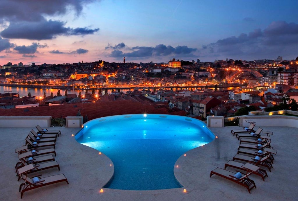 Luxury hillside wine hotel in Porto with infinity pool overlooking Douro River, historic port wine cellars and city skyline at sunset