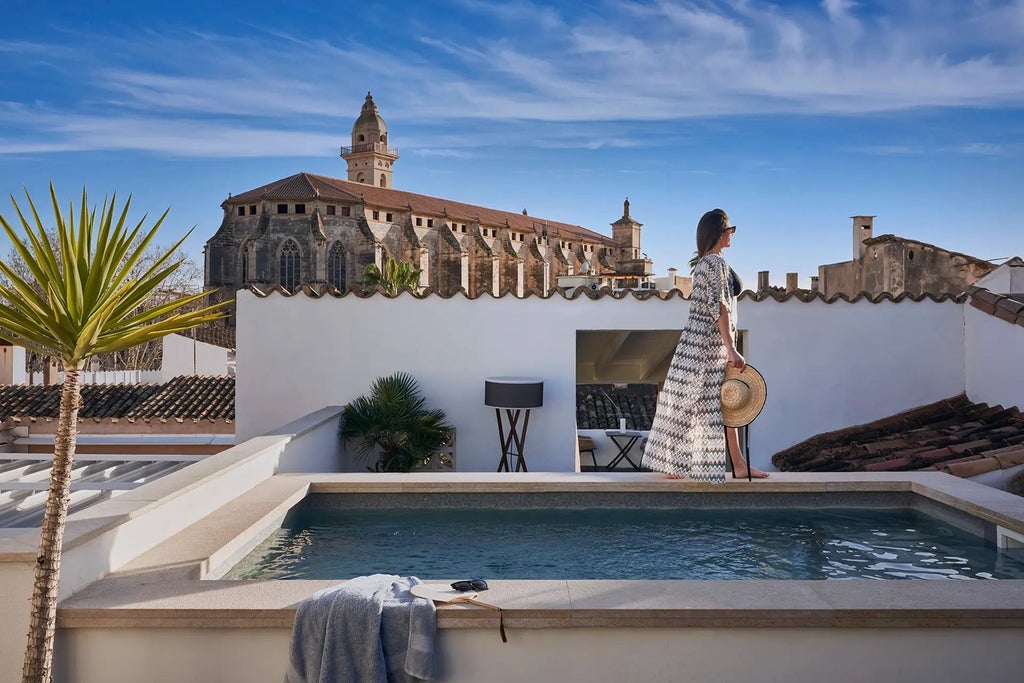 Elegant boutique hotel with stone facade, traditional Mallorcan architecture, warm lighting, and lush courtyard in Palma's historic center at dusk