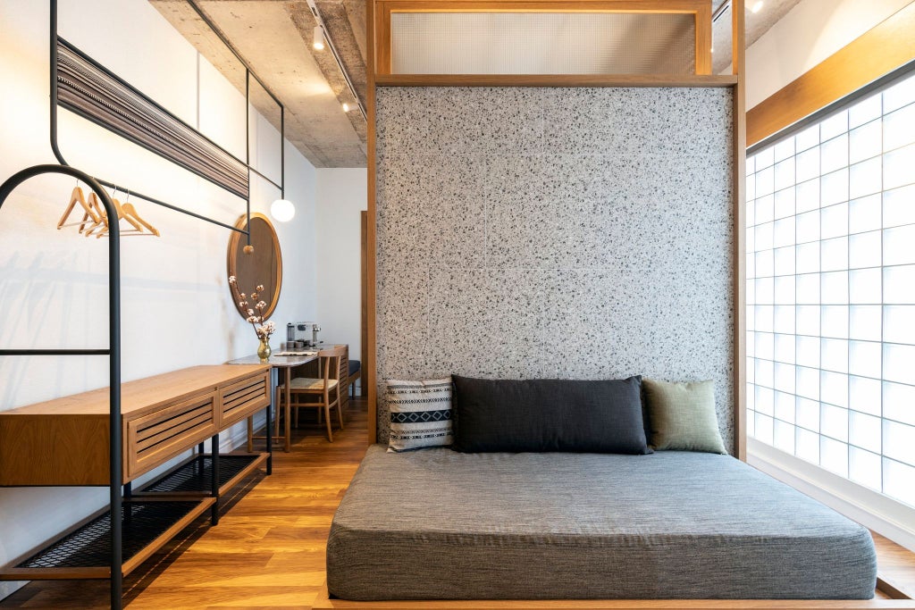 Luxurious hotel room at Scenset House Athens, featuring minimalist design, warm wooden accents, large windows with city view, and plush bedding