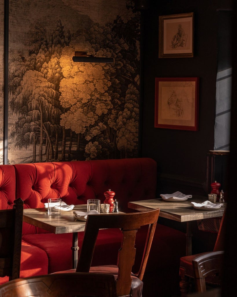 Elegant brick and wood boutique hotel facade with warm lighting, classic British architectural details and inviting restaurant exterior at dusk