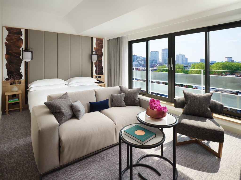 Modern luxury junior suite with contemporary design, king bed, elegant gray and white color palette, city view windows at Nobu Hotel in London Portman Square