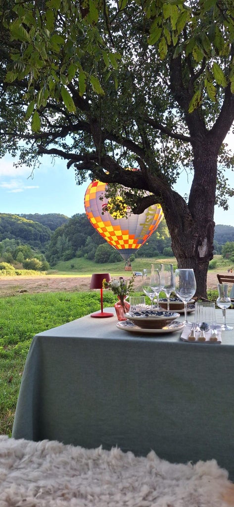 Luxurious stone manor nestled in rolling Transylvanian hills, featuring rustic architectural details, stone walls, and verdant countryside landscape at dusk