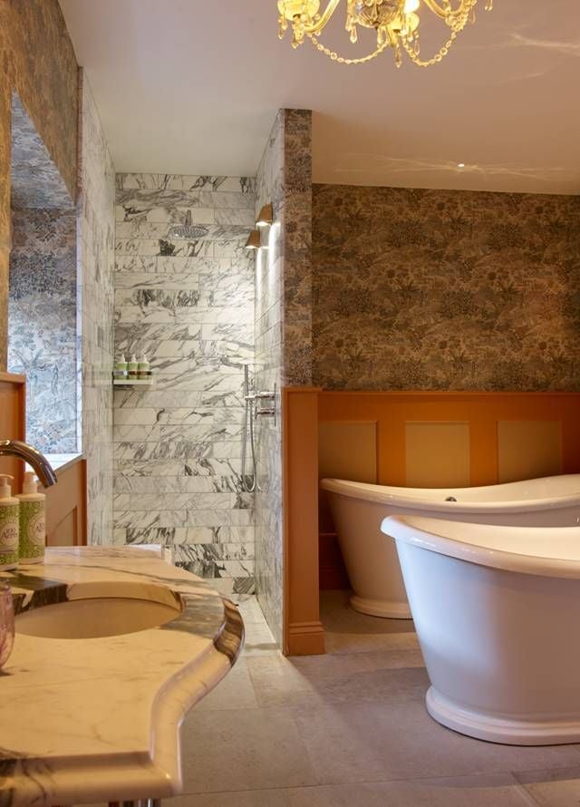 Luxurious hot tub suite with modern design, plush bed, and elegant bathroom featuring sleek fixtures and warm, inviting neutral color palette in a UK hotel room.