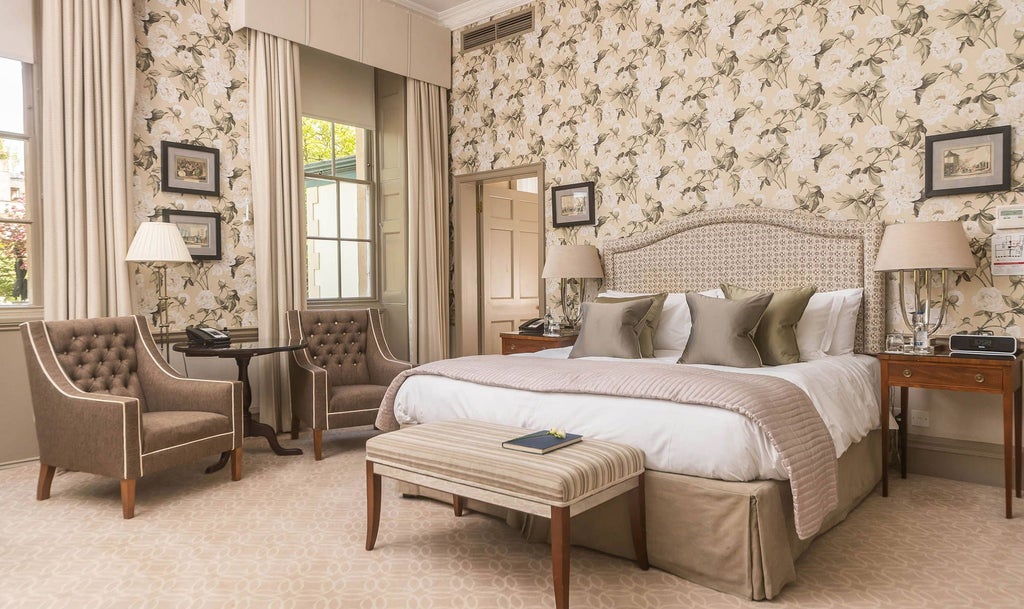 Elegant Georgian-style bedroom with cream walls, antique furnishings, plush king-sized bed, and delicate period decorations at the Royal Crescent Hotel & Spa