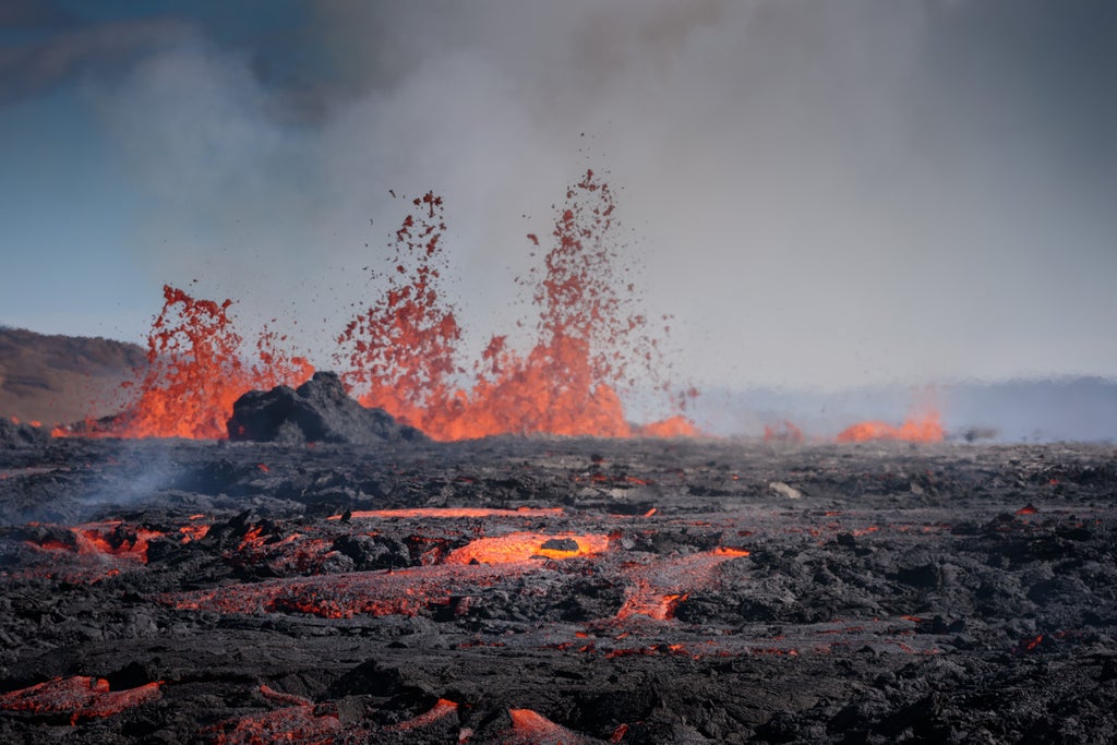 Rugged volcanic landscape of Reykjanes Peninsula, with steaming geothermal vents, stark black lava fields, and dramatic coastal cliffs under moody Icelandic sky