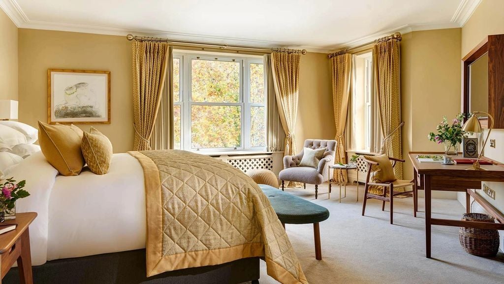 Elegant suite overlooking cascading waterfalls, featuring plush king bed, classic furnishings and floor-to-ceiling windows with Irish countryside views