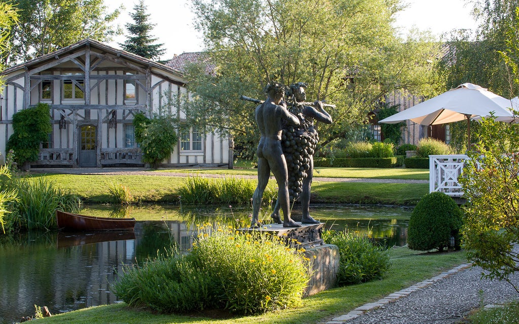 Elegant French chateau hotel nestled among vineyards, featuring stone walls, timber beams, and a serene lake reflection at dusk