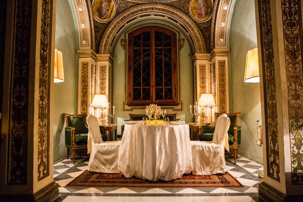 Elegant Renaissance palace turned luxury hotel in Florence with manicured gardens, ornate architecture and grand fountains at sunset