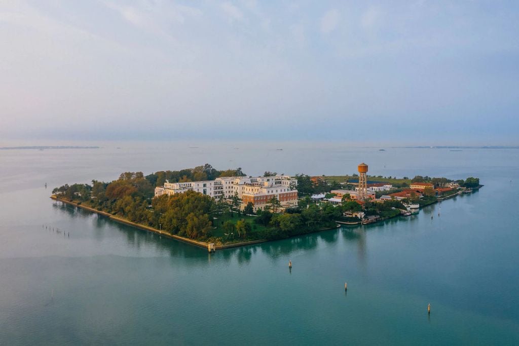 JW Marriott resort island in Venice, with elegant waterfront terrace overlooking lagoon, luxury lounge seating and grand architecture