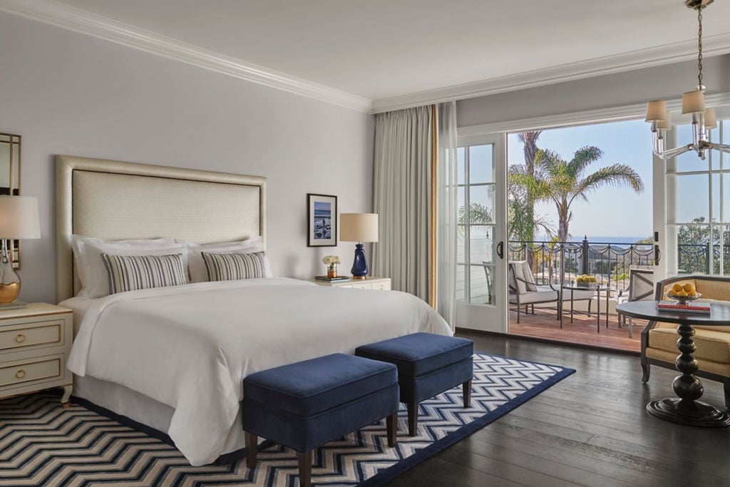 Luxurious terrace guestroom overlooking pristine beach, featuring elegant outdoor seating and sweeping coastal views at Rosewood Miramar Beach resort