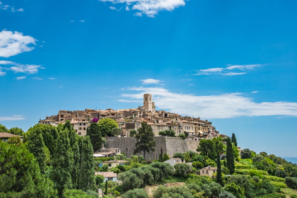 Medieval hilltop town Saint-Paul-de-Vence with stone buildings and cobblestone streets overlooking Mediterranean coast at sunset