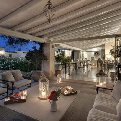 Elegant Sicilian villa with lush gardens, stone walls, and Mediterranean architecture, showcasing luxurious outdoor terrace with traditional Italian design elements