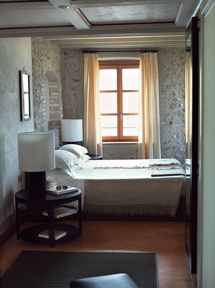 Elegant Italian suite at Hotel Salò Villa Arcadio overlooking Lake Garda, featuring plush white bedding, antique furnishings, and expansive lake view through large windows